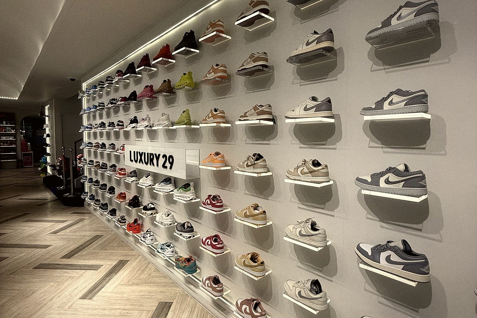 A wall of sneakers under strip lighting in a retail store.